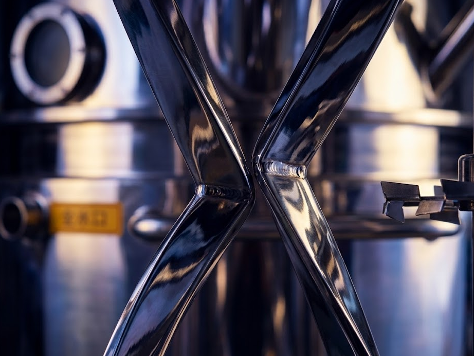 Close-up of a polished stainless-steel industrial slurry mixing vessel